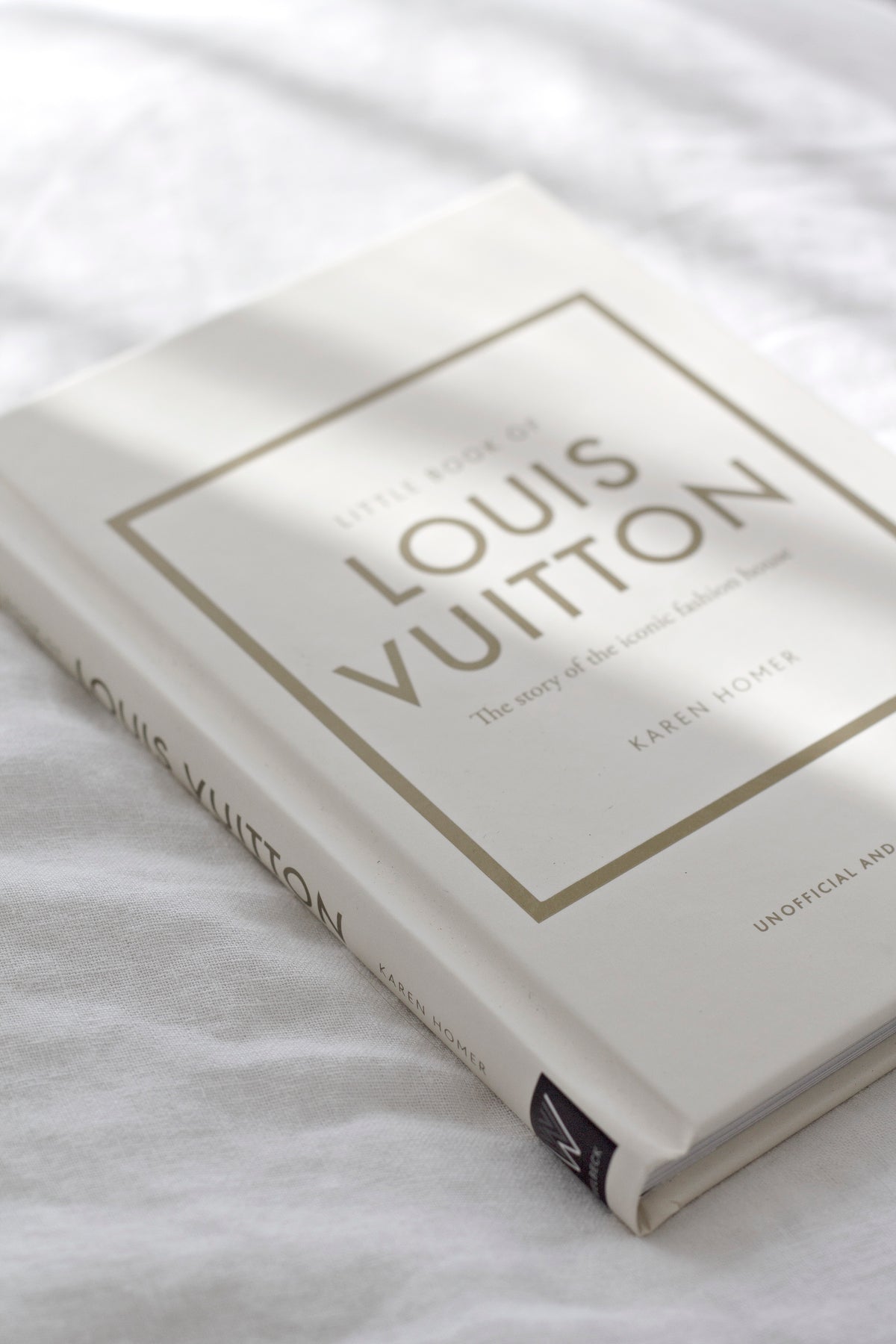 Little Book of Louis Vuitton styled on a shelf with neutral home decor