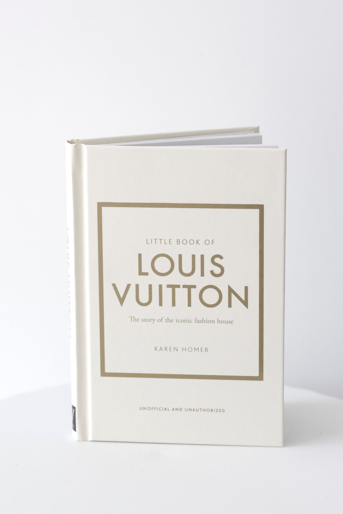 Little Book of Louis Vuitton styled on a bedside table with candle