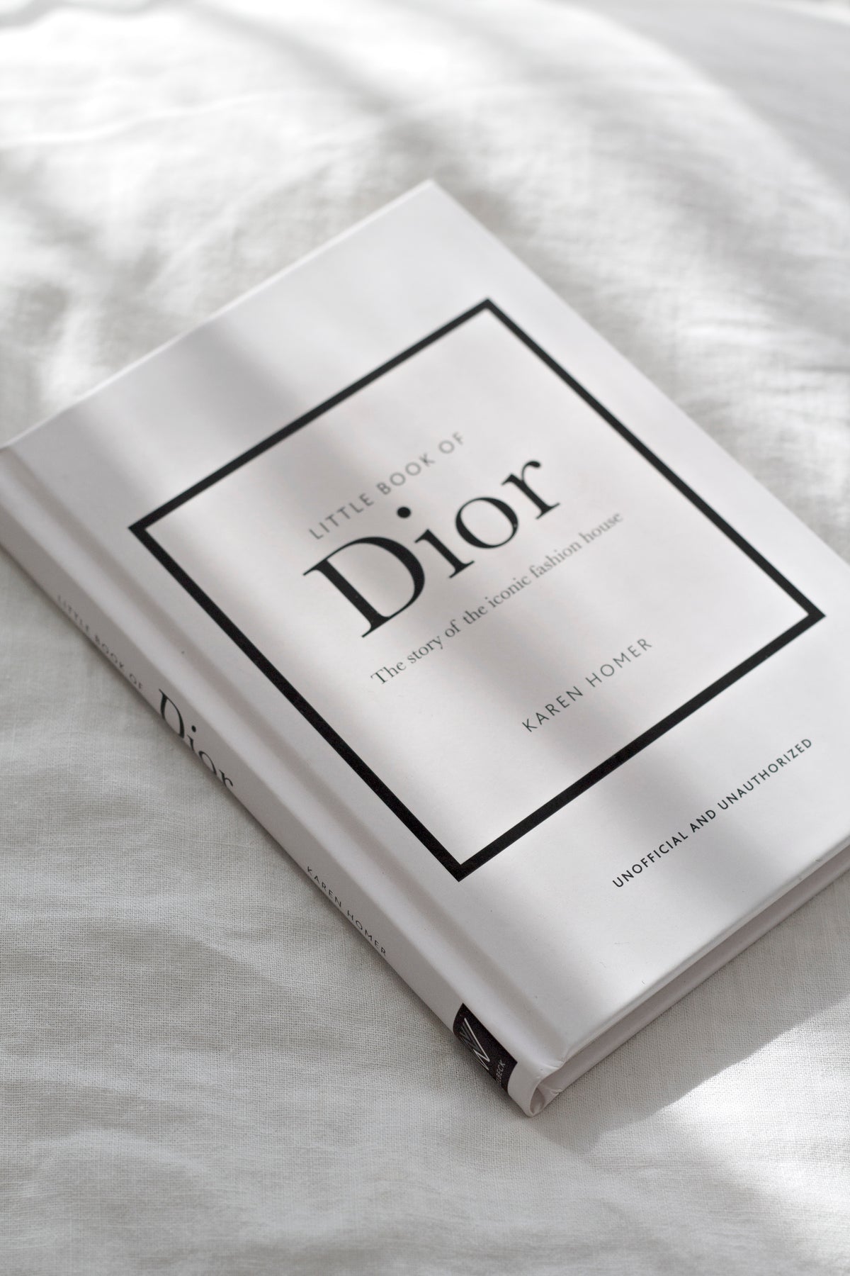Little Book of Dior stacked with other fashion titles on a coffee table