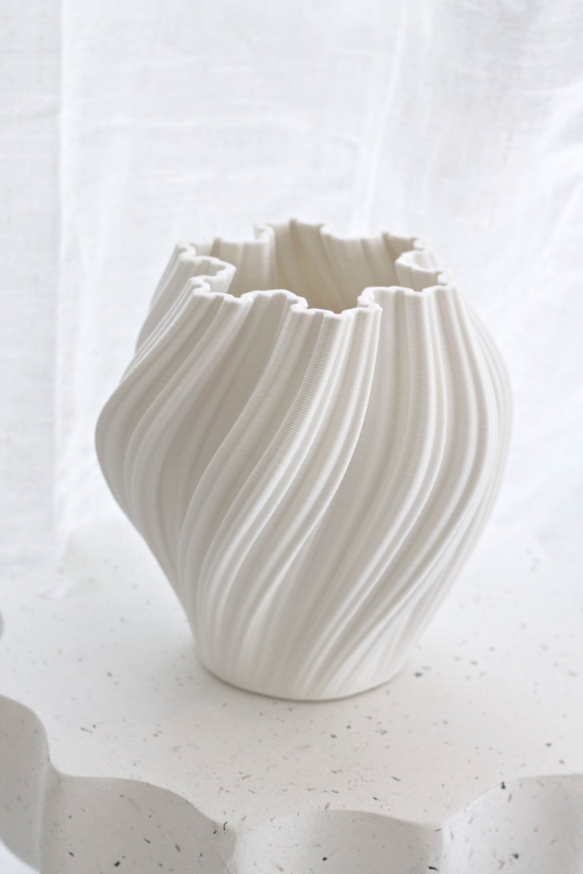 Empty white Amelie fluted vase on a pale plinth against a linen backdrop