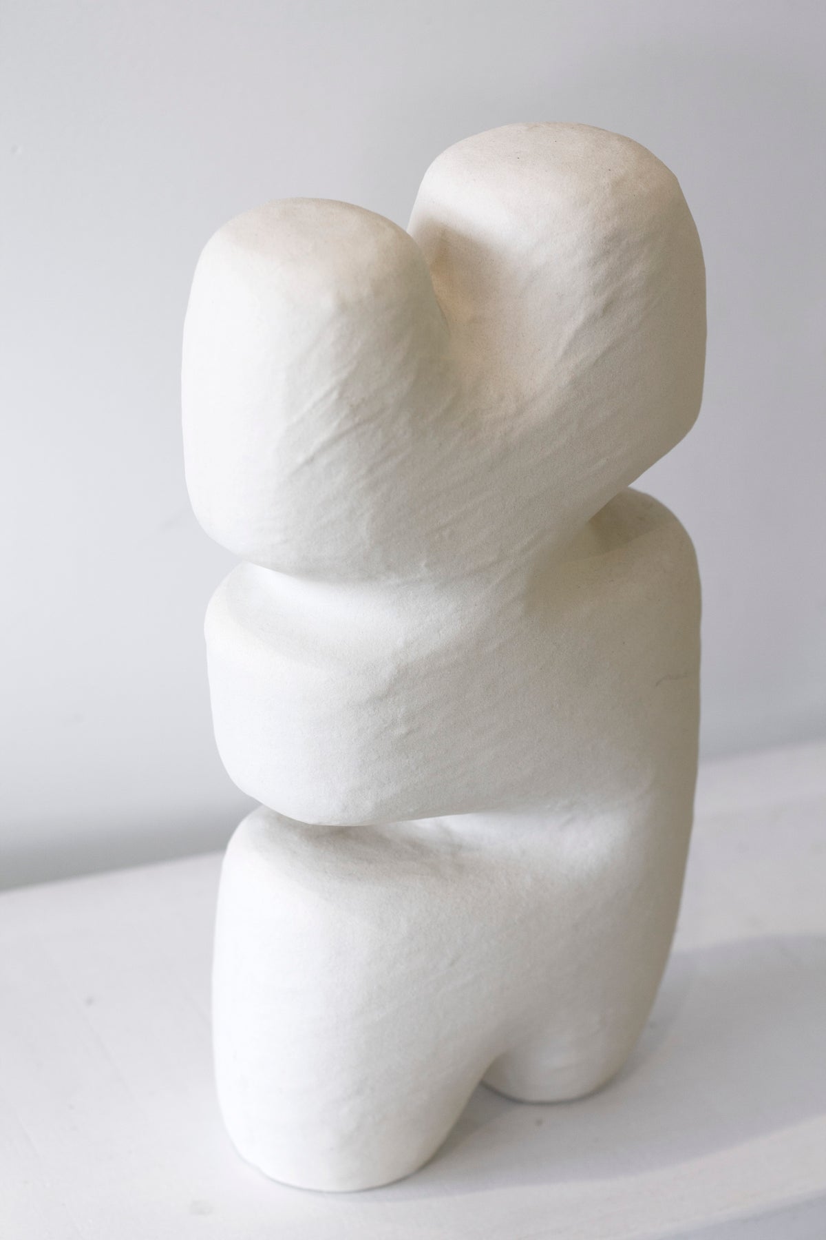 Block sculpture in close view, soft light rounding the shoulders and waist