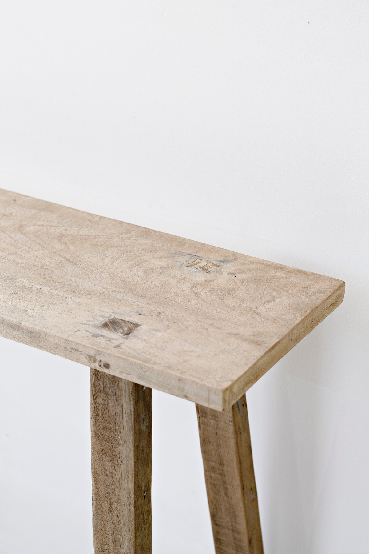 Close up of the recycled teak tabletop and leg, showing the timber grain and patina
