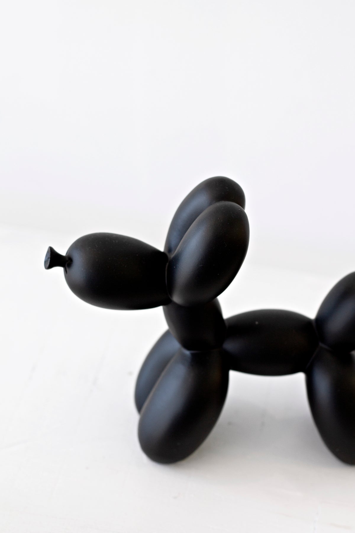 Black ceramic balloon dog sculpture, close angled view