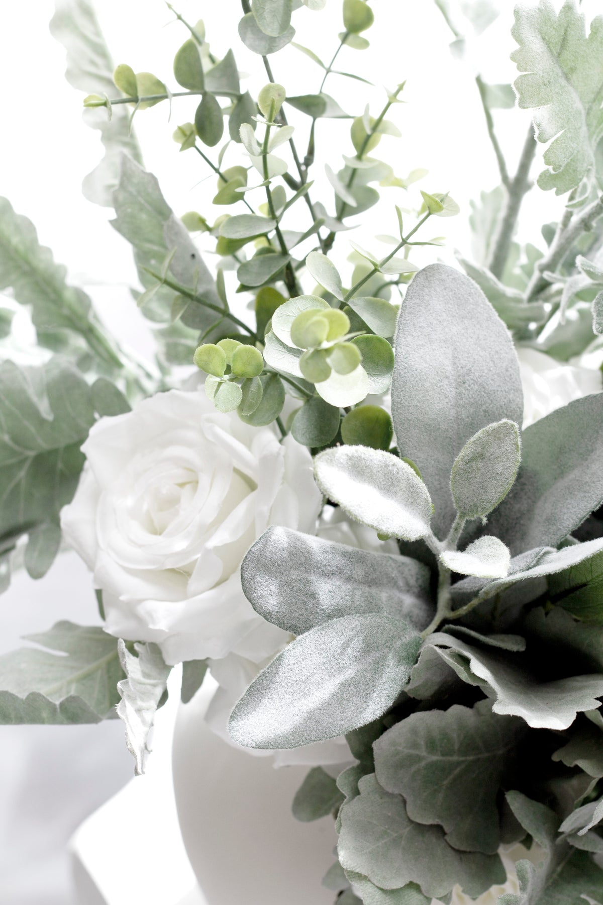 Lamb's ear with white roses and eucalyptus in a white vase