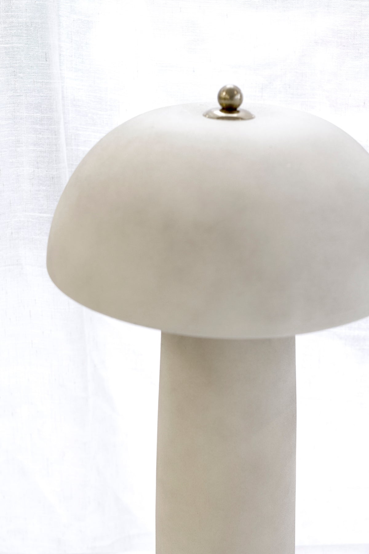 Close view of the mushroom shade and brass finial