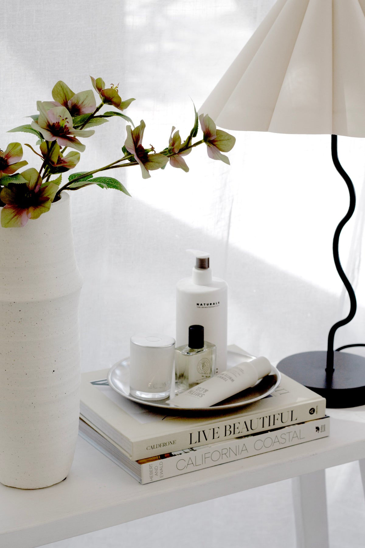 Round stainless steel decor tray styled with candle and perfume