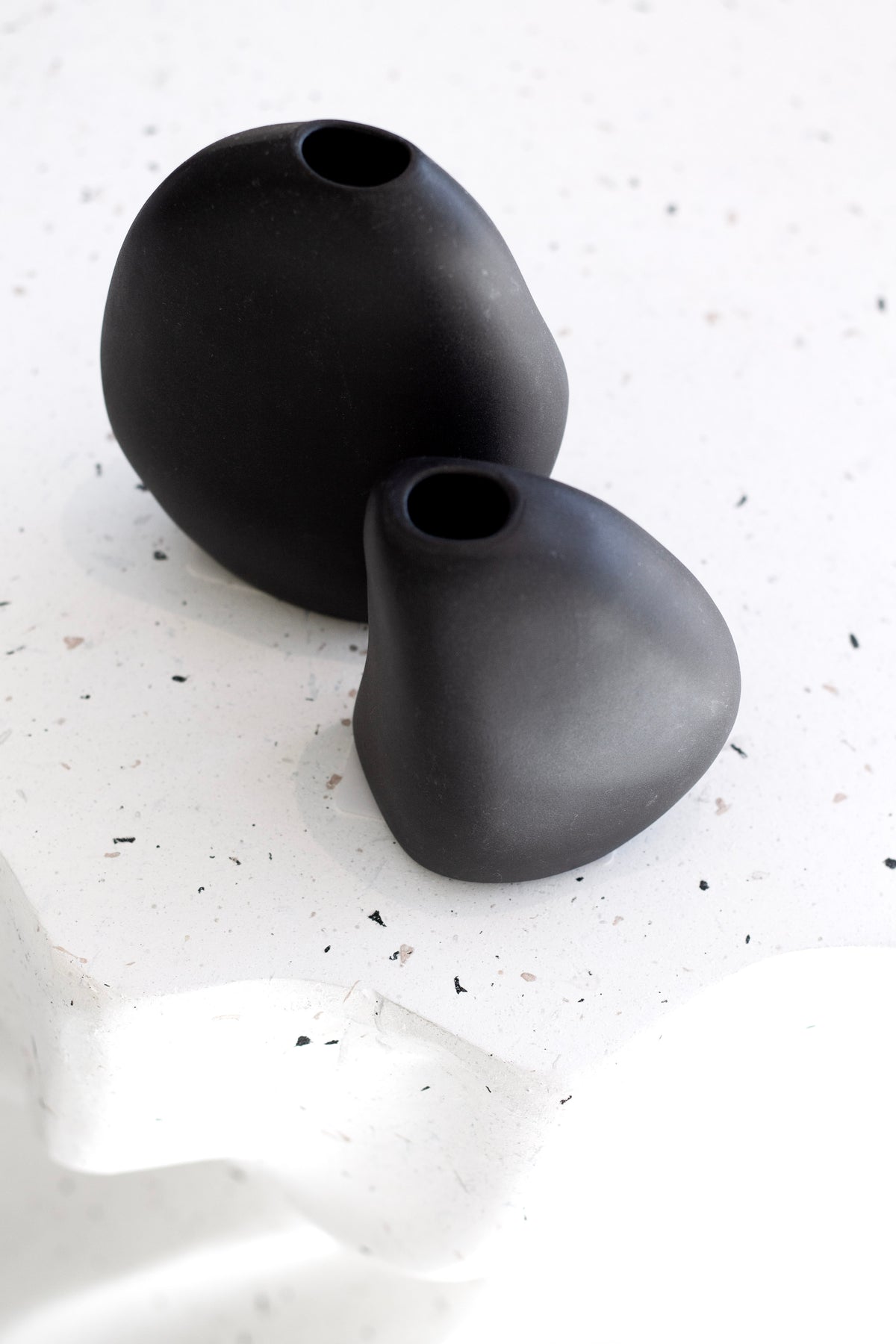 Harmie Stone Black Vase styled on a stack of books