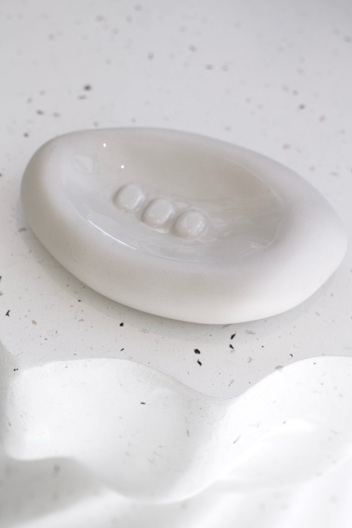 Haan Accessory Dish in cashmere styled on a bathroom vanity
