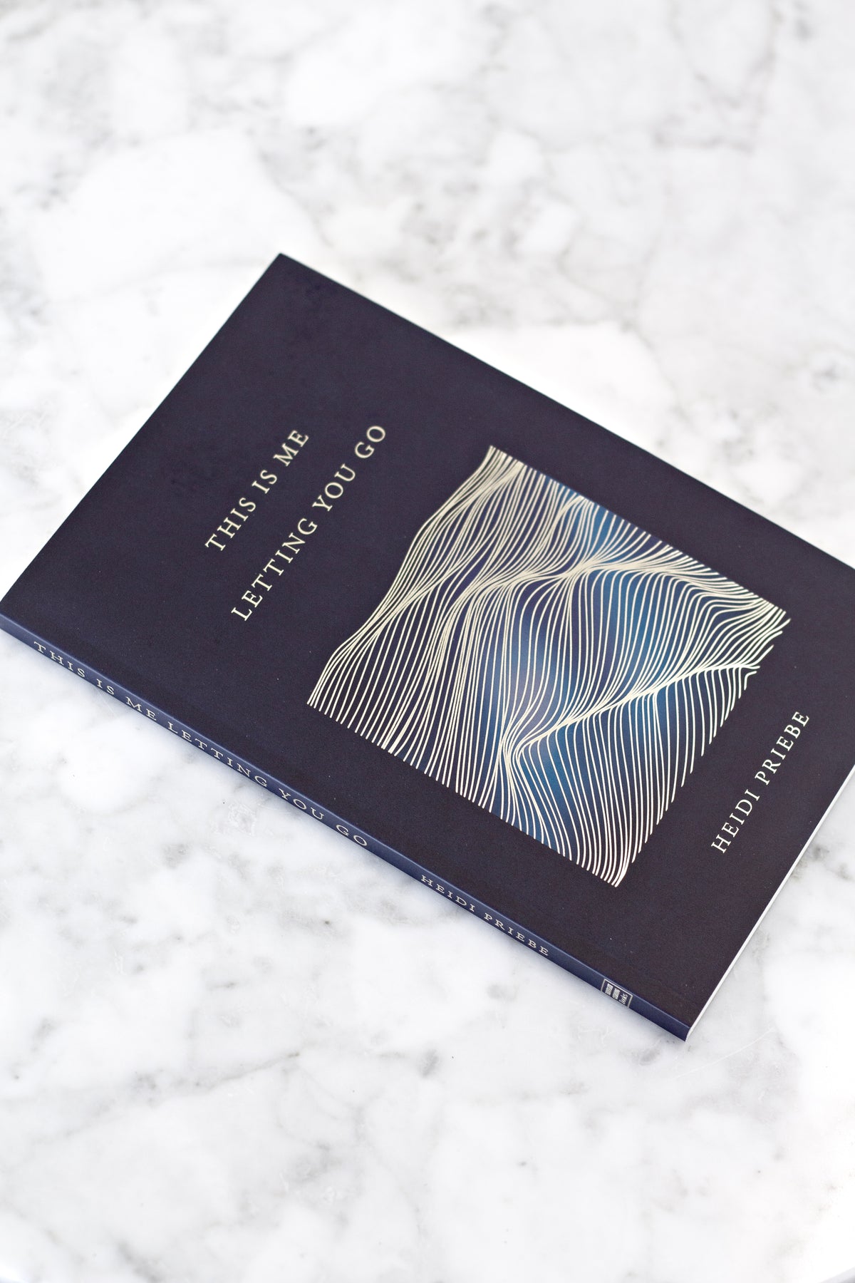 This Is Me Letting You Go lying at an angle on white marble