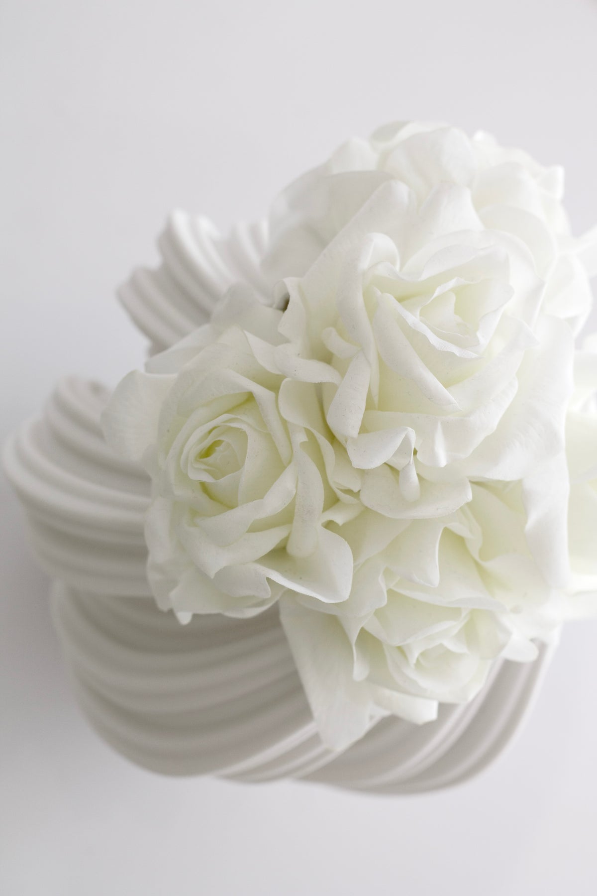 Close up of the white Amelie fluted vase filled with white roses and hydrangeas