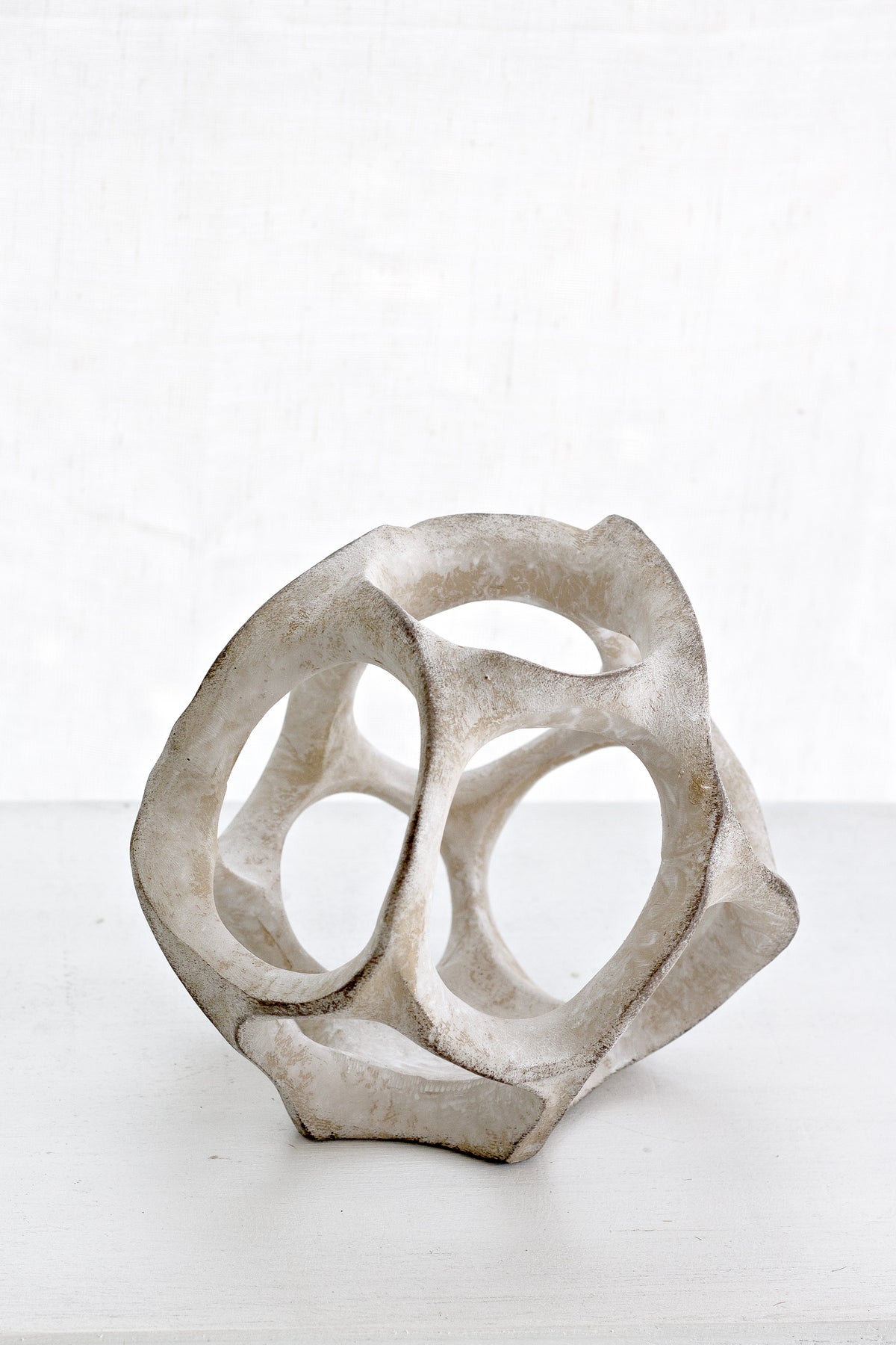 Cosmo resin sphere on a white ledge against a pale wall