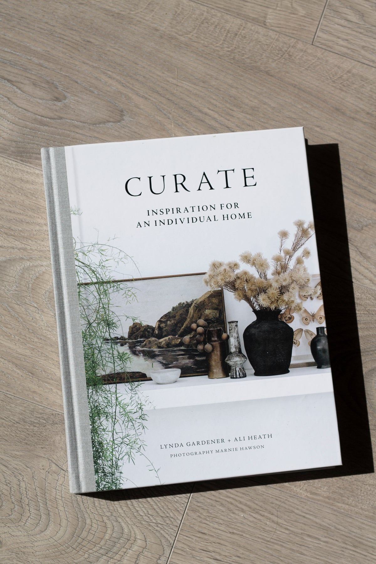 Curate book styled on a shelf with neutral home decor