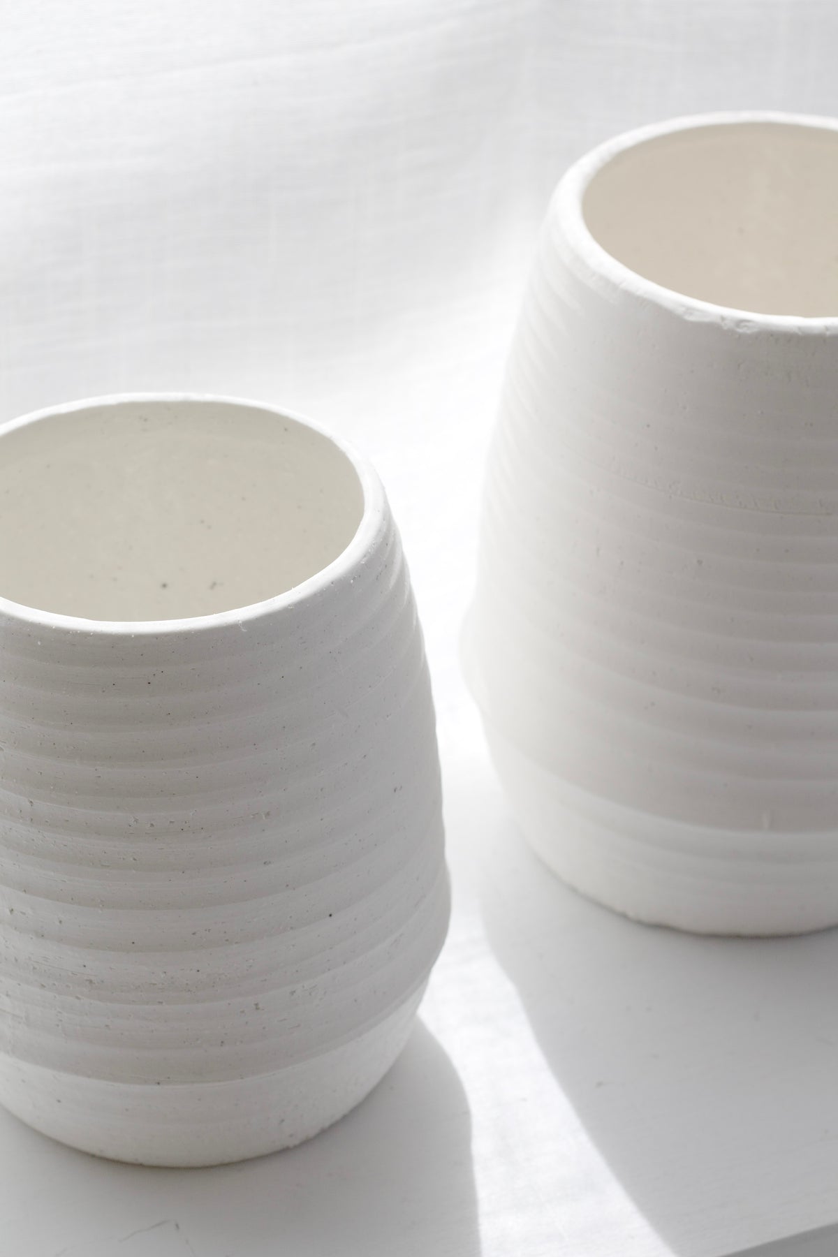 Close view of two Alma vases showing the fine ribbed texture and matte chalk finish