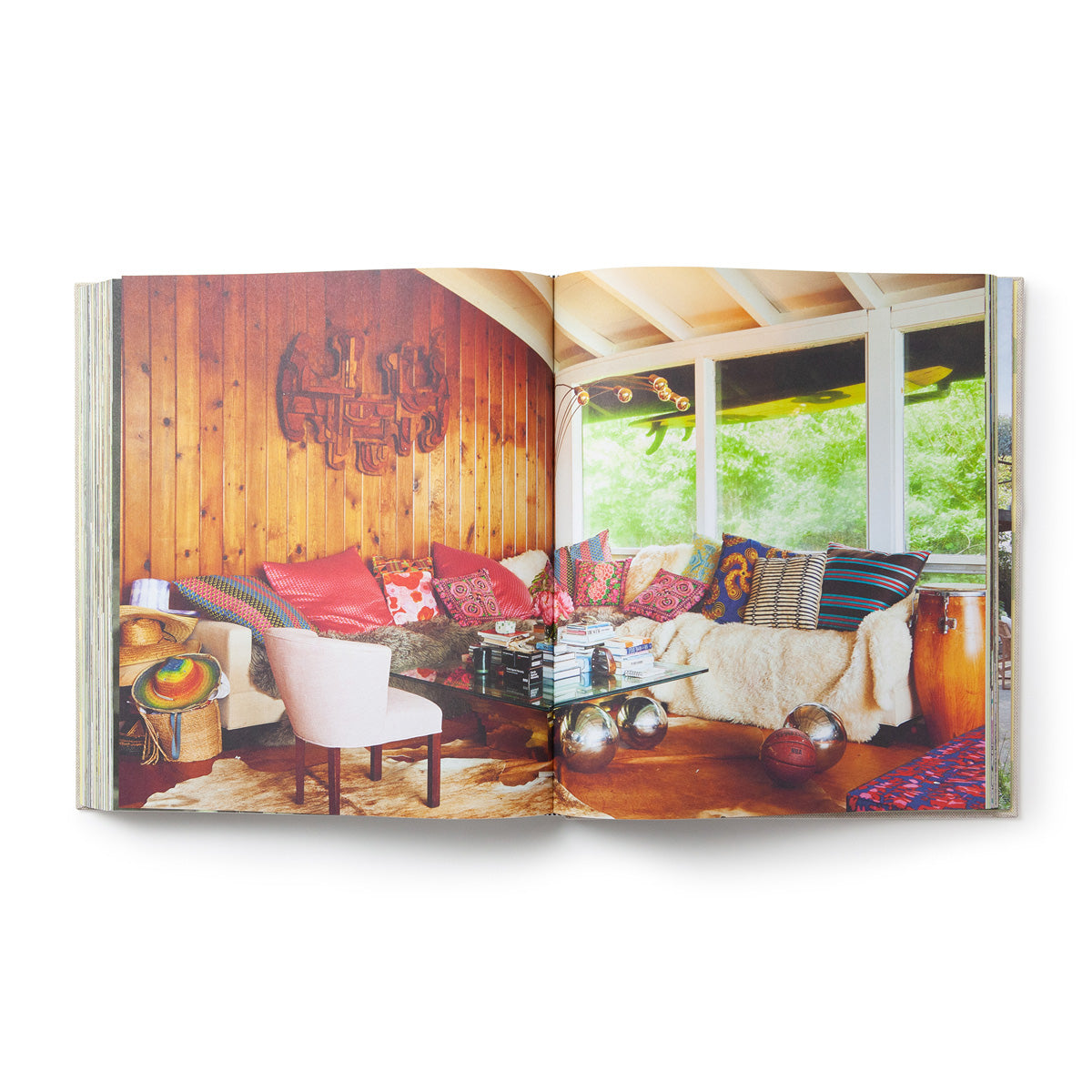 Spread of a timber-lined living room with a red rug and patterned sofa