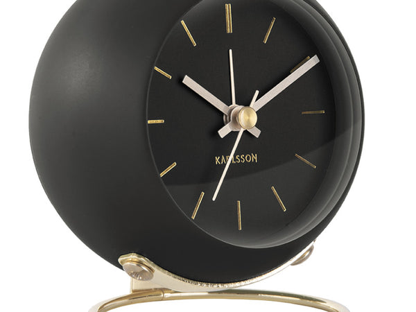 Close-up of the Black Globe clock's dial with gold-tone hands and stand