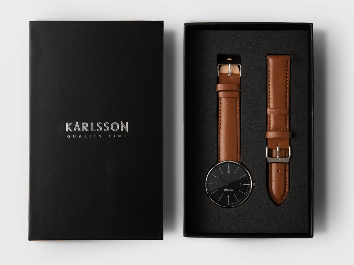 Karlsson Normann watch with a black dial in its presentation box with a spare tan leather strap