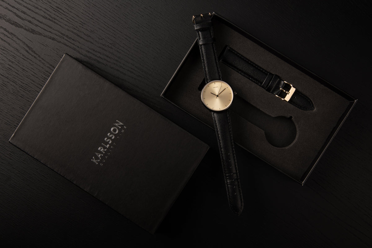 Karlsson Finesse watch in its open gift box on a dark surface with the lid alongside