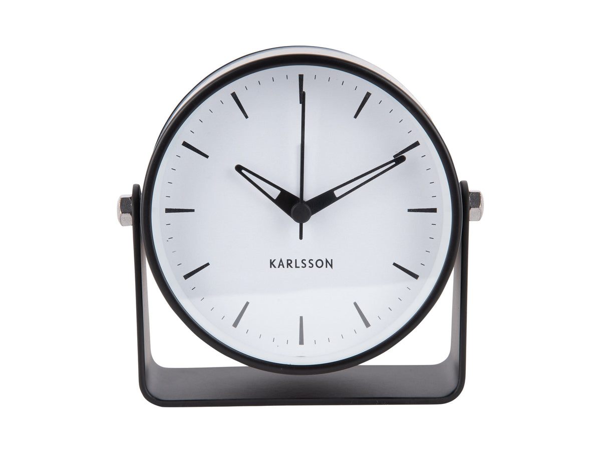 Front view of the black Karlsson Calm alarm clock with white dial and curved stand