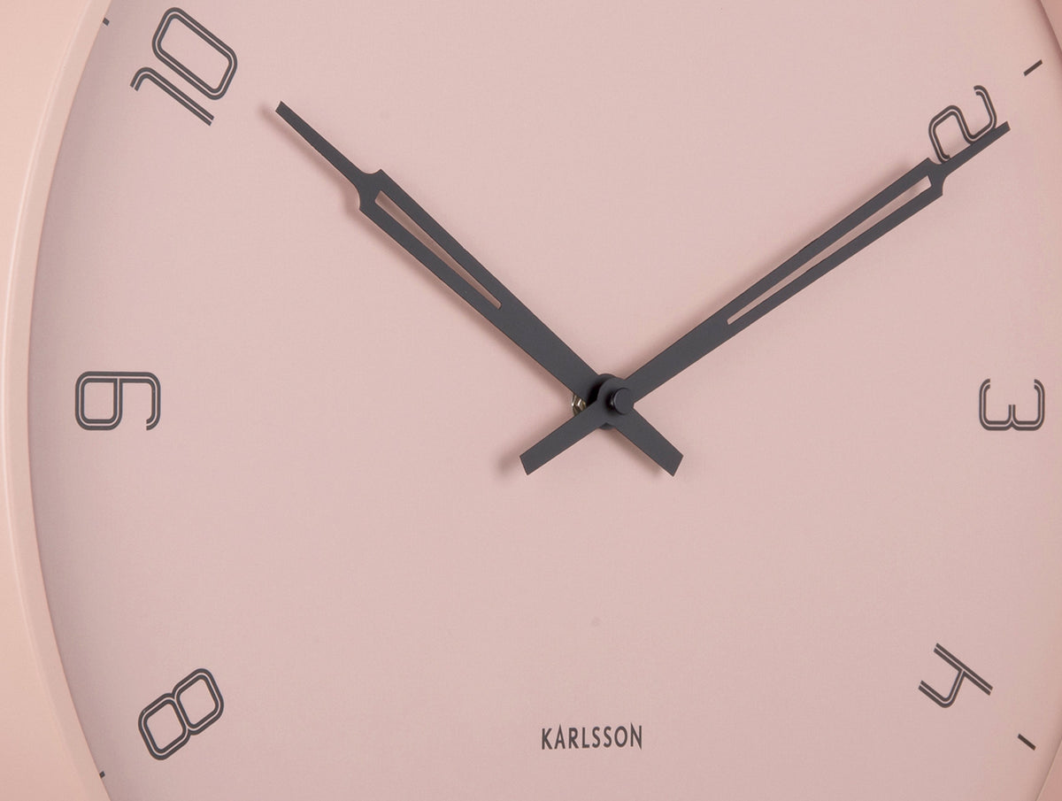 Close crop of the faded pink Stark clock face with black hands