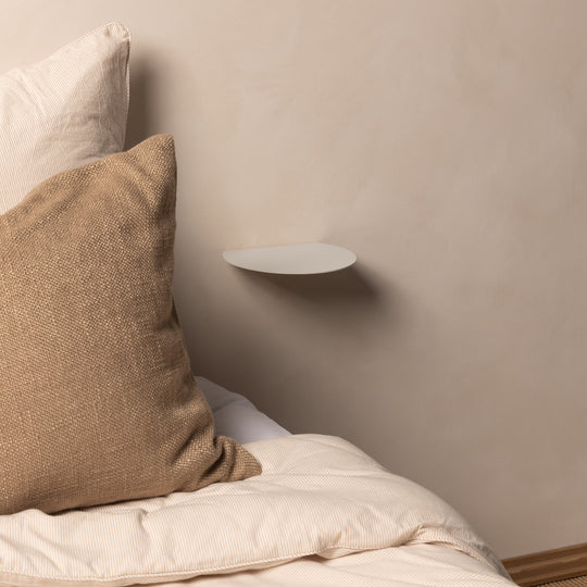 White FOLD Round Shelf mounted above a bed with linen cushions