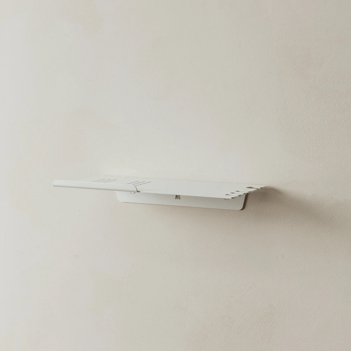 Empty white FOLD shower shelf mounted on a grey wall