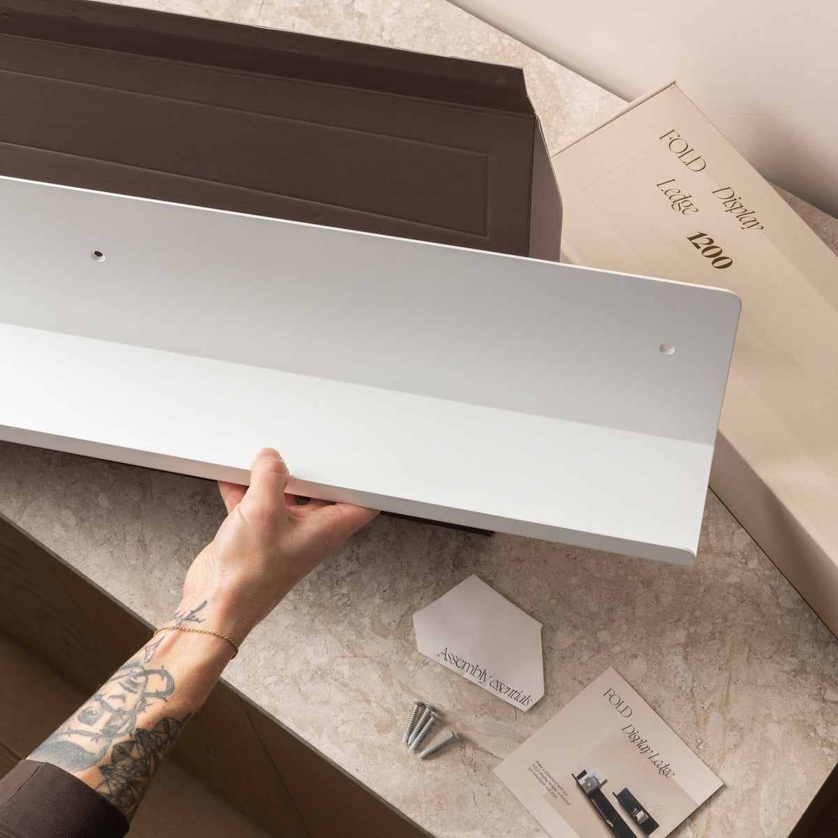 FOLD Display Ledge 600mm White mounted in a bathroom holding a candle and small plant