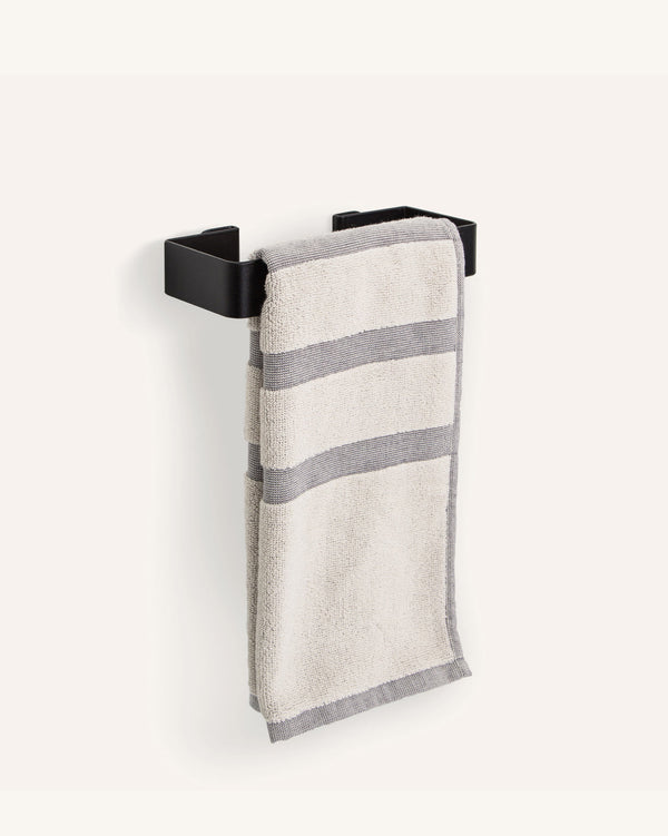 A Scandinavian-inspired FOLD Hand Towel Holder ∙ Black, part of our stylish bathroom range, complete with a crisp white hand towel hanging effortlessly from it. Made of Tomorrow