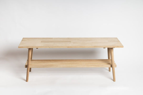 The Ned Collections David Long Bench, an American Oak coffee table with a shelf on it, known for its strength and durability.
