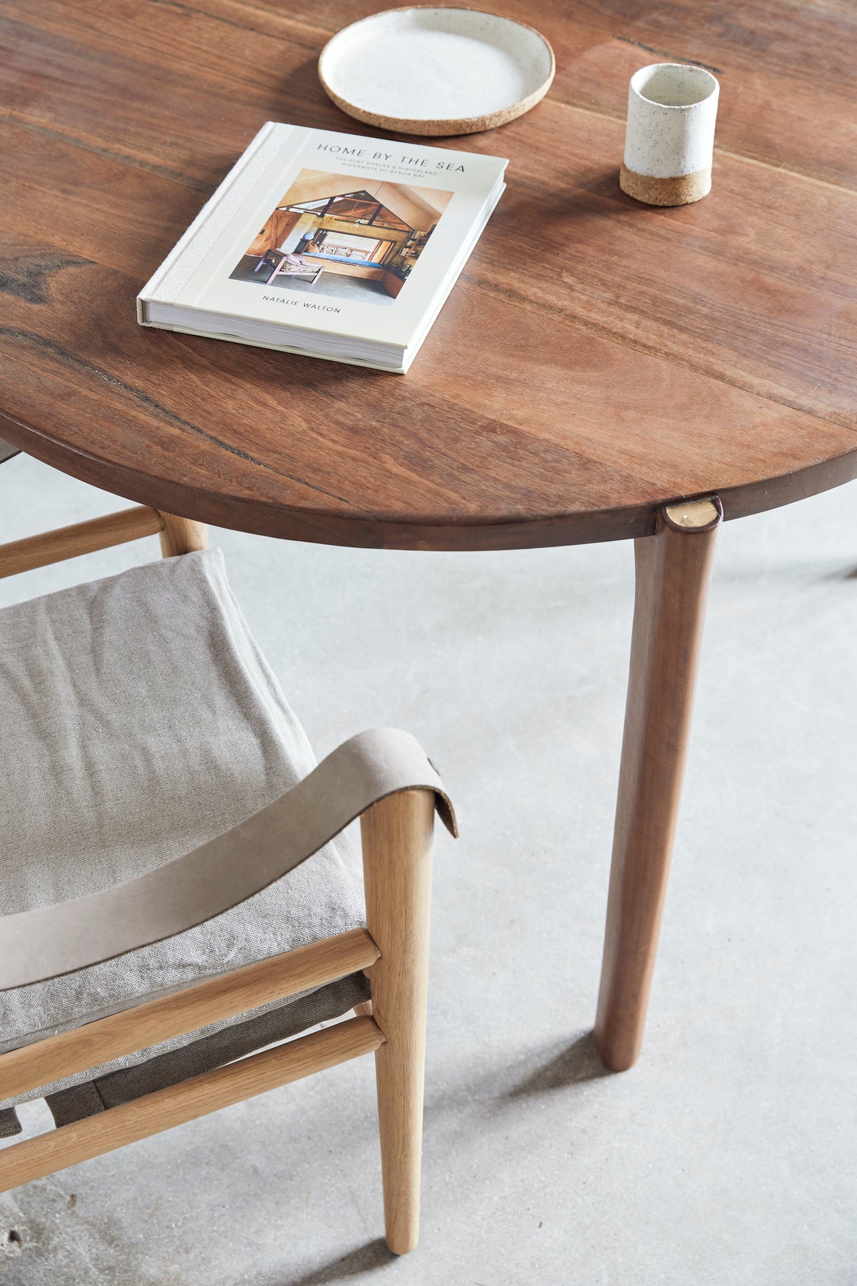 A creative community workspace in Byron Bay with a wooden "Home By The Sea" table and chair adorned with a "Books" interiors book.