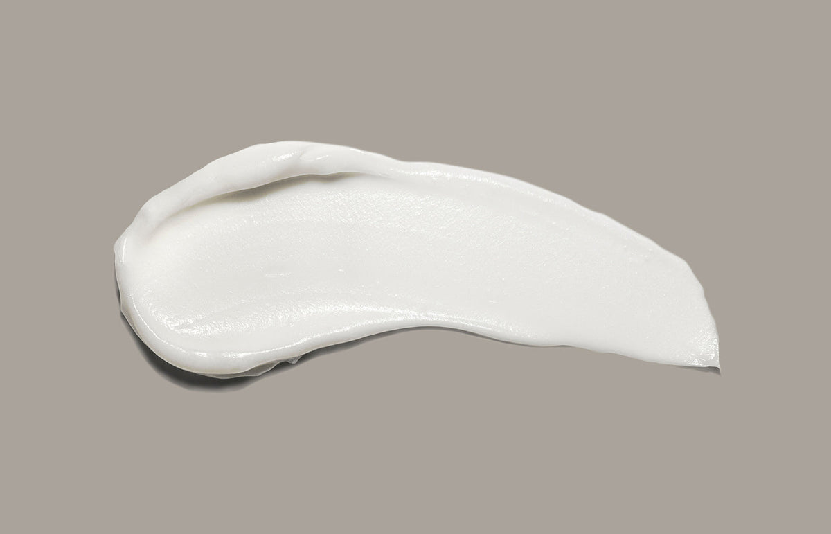 A swipe of white Naturals lotion on a taupe background