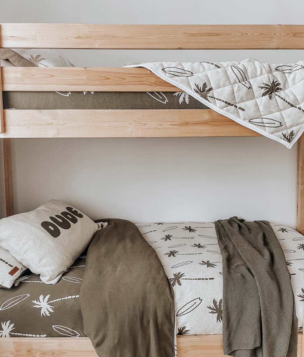 Bunk beds with a Surfing Palm reversible quilt over the top bunk and olive Surfing Palm bedding below