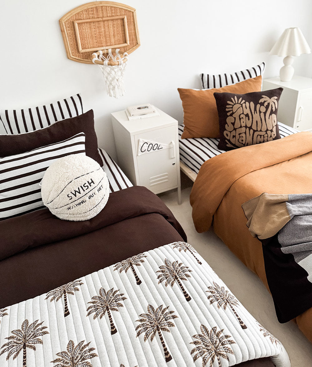 Shared kids room with two beds, the basketball sherpa cushion sitting on the chocolate bed