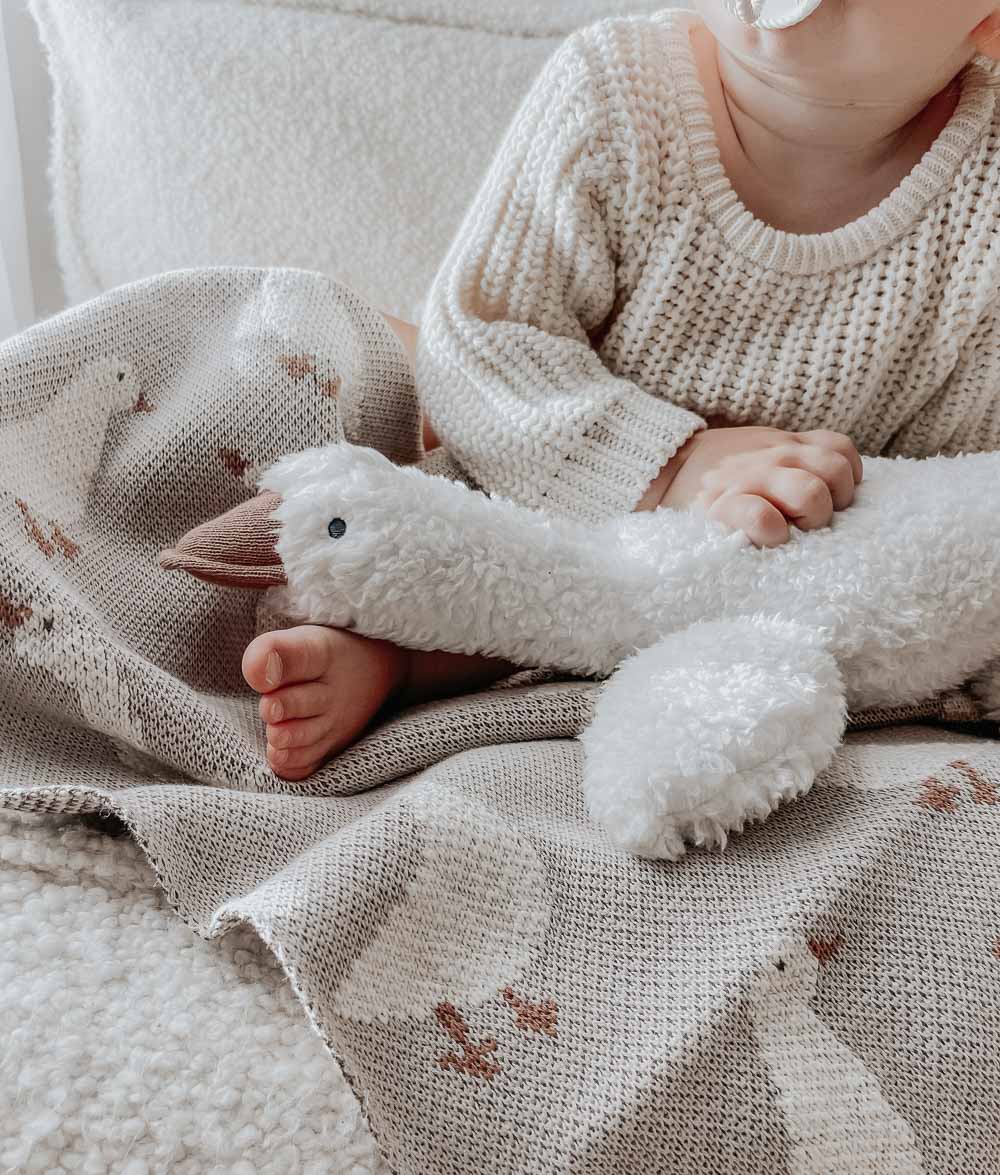 Toddler in a knit jumper cuddling the Gary the Goose sherpa comforter