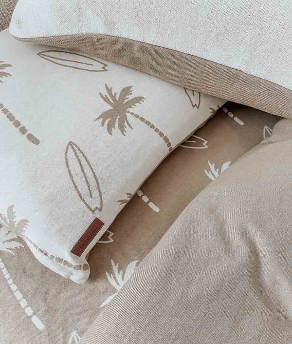 Natural Surfing Palm kids cotton pillowcase with sand print and leather label on a sand fitted sheet