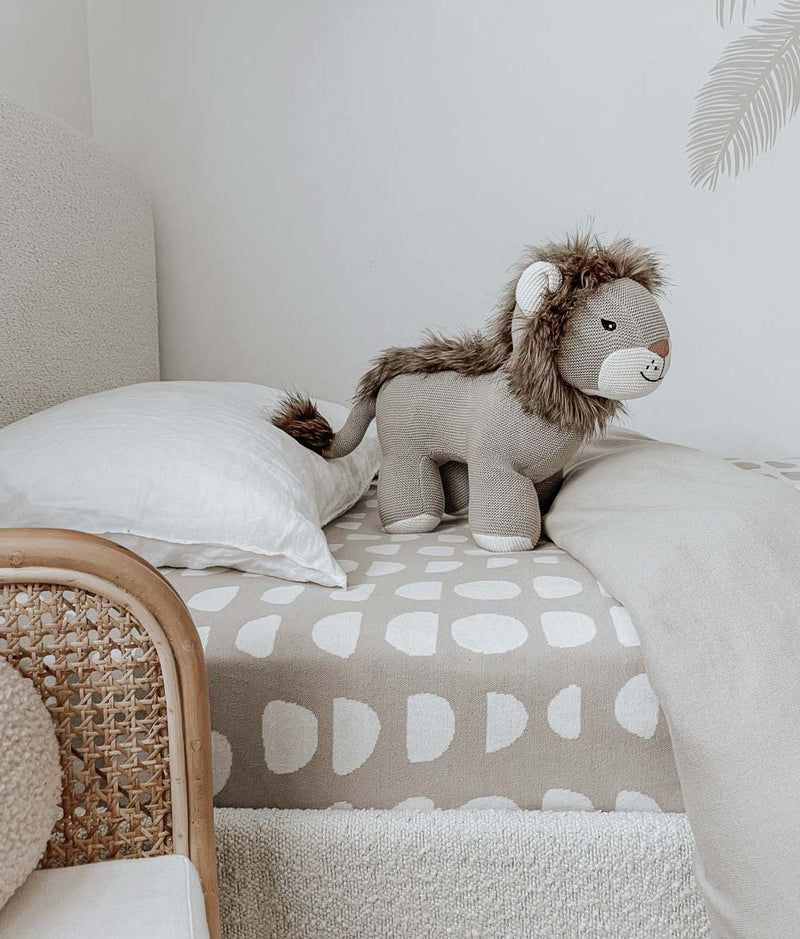 A child's bedroom with a Bengali Collections LION TOY on the bed.