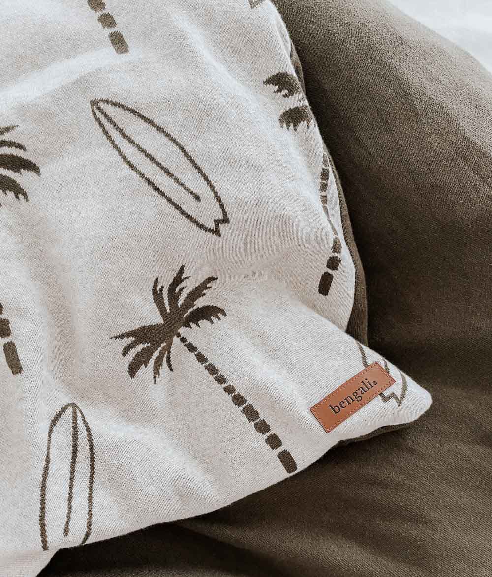 Close-up of a Surfing Palm kids duvet cover corner with olive palm and surfboard print and a small leather Bengali label