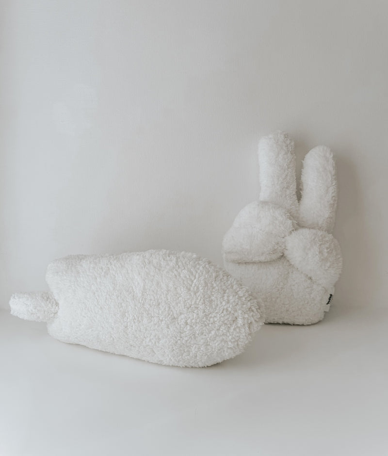 Peace Sherpa kids cushion beside a second ivory Sherpa cushion lying down on a white backdrop