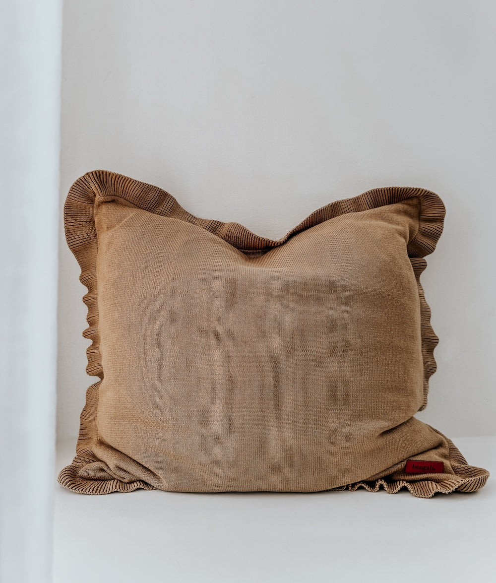 Khaki euro pillowcase with a frill edge standing alone against a plain white wall