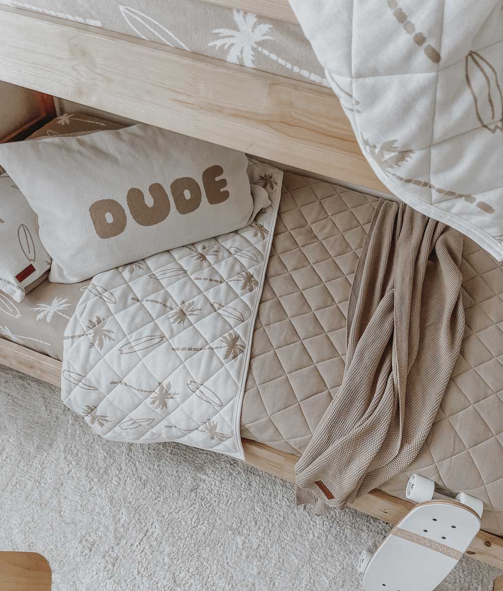 Lower bunk with the Surfing Palm reversible quilt, its sand quilted reverse, a DUDE pillowcase and knit throw