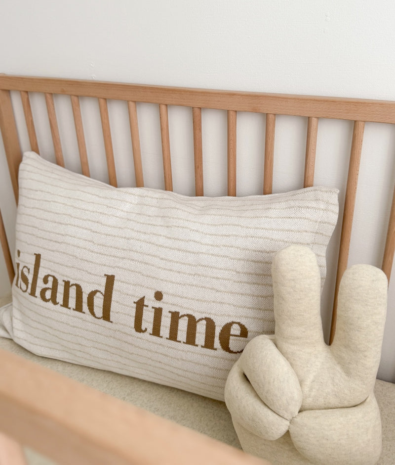 Island Time cotton pillowcase in a timber cot beside the ivory Peace Sherpa cushion