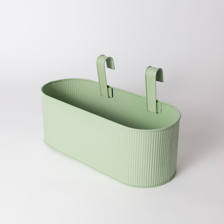 Juno hanging planter in sage green with two curved hooks, on white