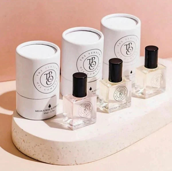 Several roll-on perfume oil bottles grouped on a stone plinth