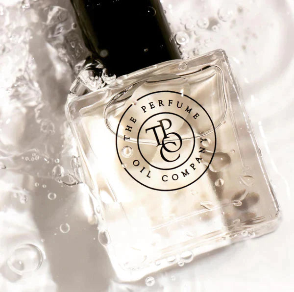 Close view of a roll-on perfume oil bottle with water droplets and ripples