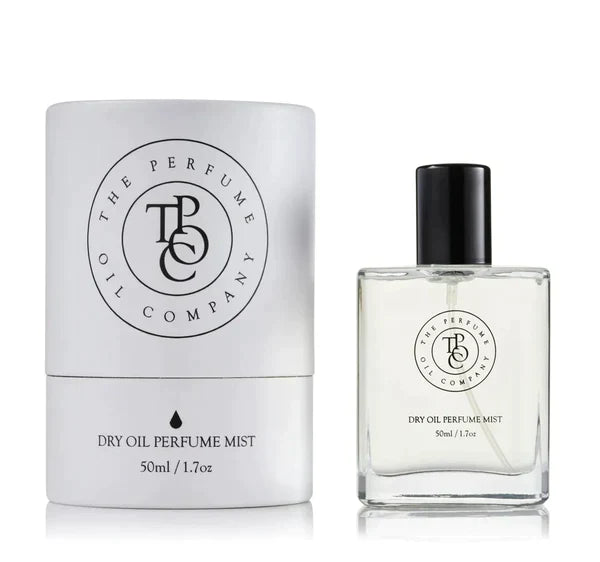 Dry oil perfume mist bottle beside its printed carton, on a plain background