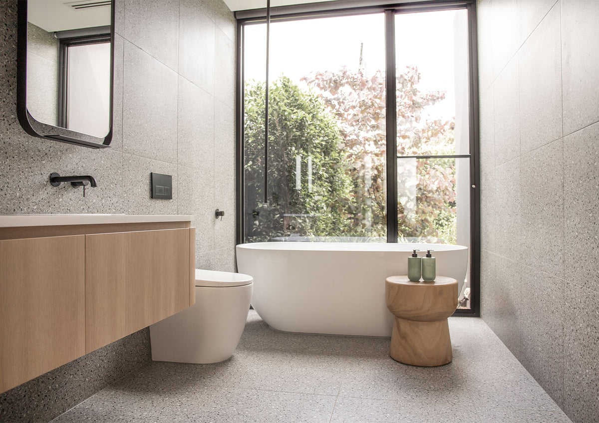 Bathroom with a freestanding bath and Smith & Co. bottles on the vanity, wide view