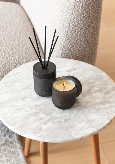 Smith & Co. diffuser and candle on a round marble side table, seen from above