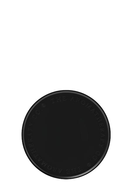 Therapy round candle and diffuser plate in matte black with an embossed rim, on white