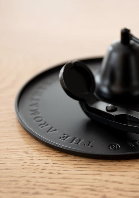 Close up of the embossed Aromatherapy Co lettering on the black plate with a snuffer and trimmer