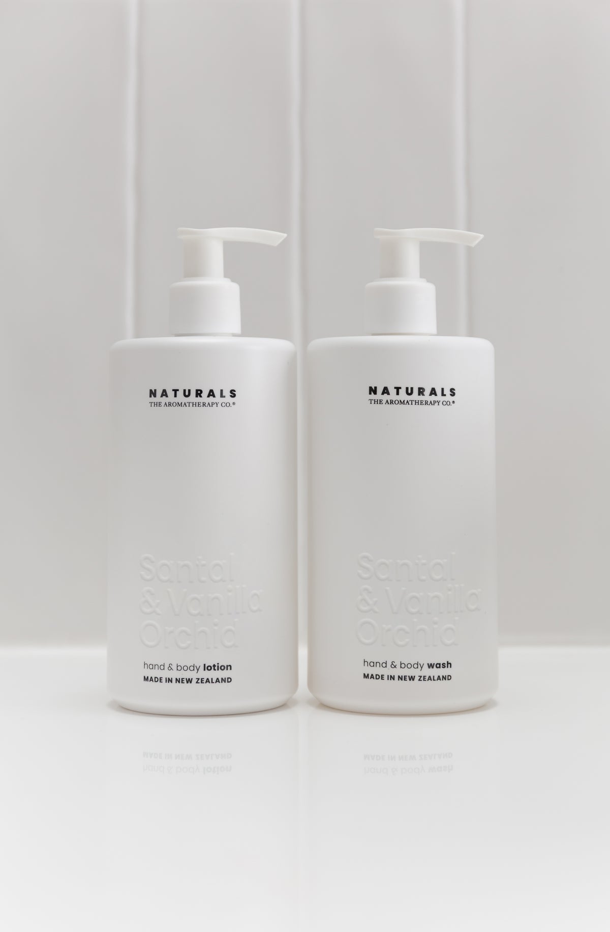 Two frosted white Naturals 400ml pump bottles side by side on a pale surface