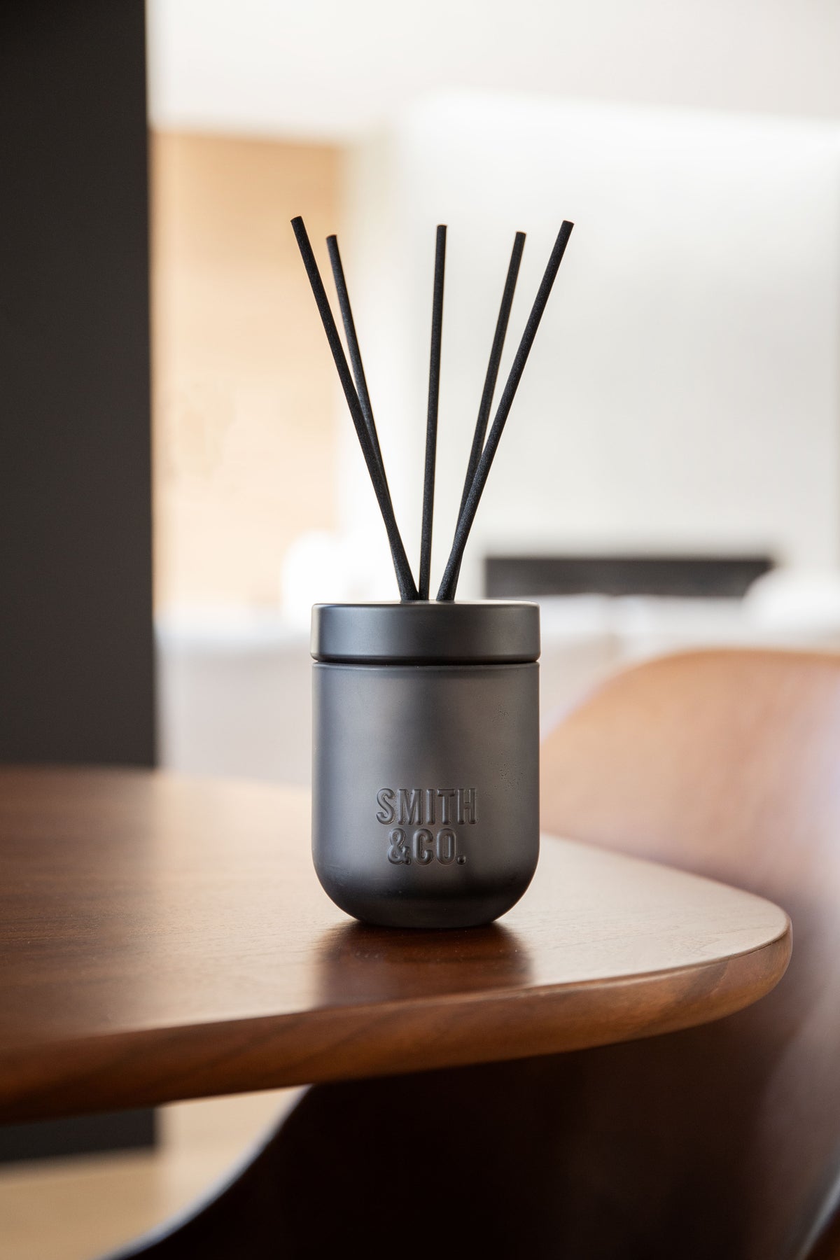 Smith & Co. diffuser on a curved dark timber table in a modern room